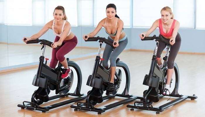 Las niñas hacen ejercicio en bicicletas para adelgazar