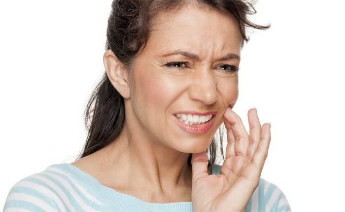 Uma mulher tem uma dor de dente