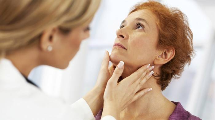 El médico revisa la glándula tiroides de una mujer.