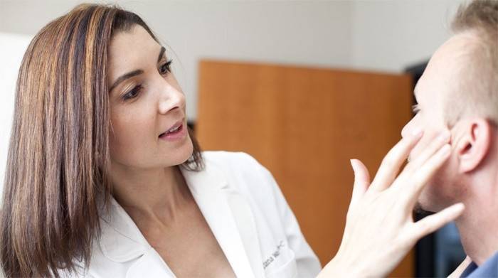 Homem na consulta com um dermatologista