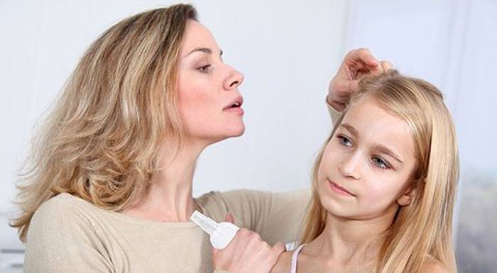 Mãe examina o cabelo da filha