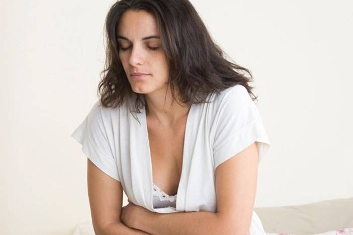 La mujer tiene dolor de estómago.