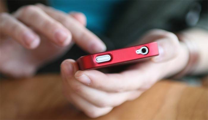 Um homem tem um smartphone na mão