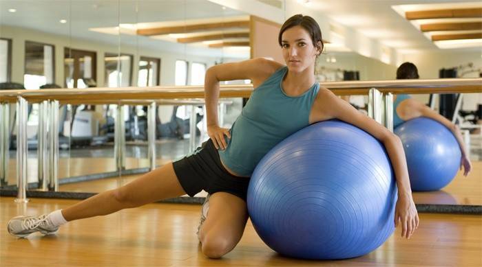 A menina está envolvida na ginástica Bubnovsky na bola
