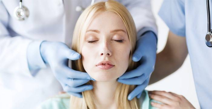 O médico examina a garganta do paciente