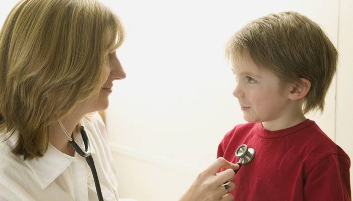 El médico determina las causas de la tos seca en un niño.