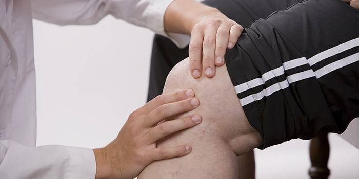 El doctor examina la rodilla de un paciente