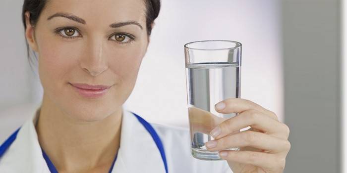 Niña sostiene un vaso de agua