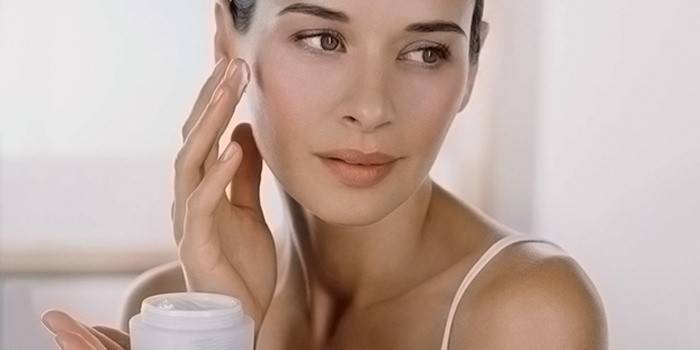Chica aplicando crema exfoliante