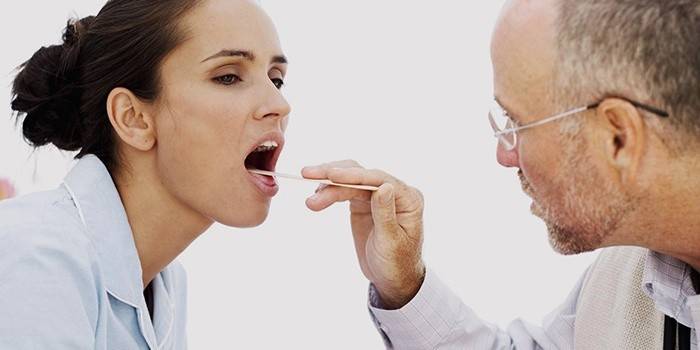 O médico verifica a garganta de uma menina