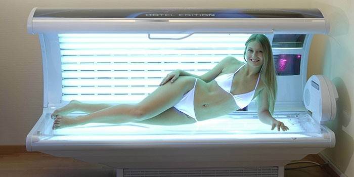 Garota em uma cama de bronzeamento horizontal