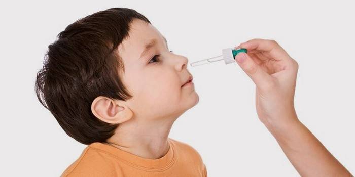 Dioxidina se gotea en la nariz de un niño