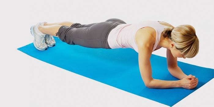 Una mujer está haciendo un ejercicio para tratar una hernia lumbar.