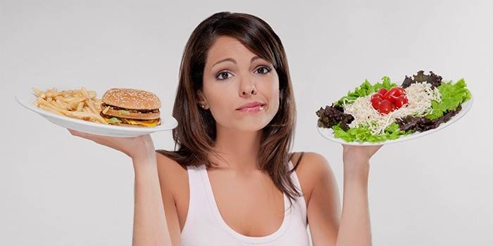 Chica elige entre comida rápida y ensalada.