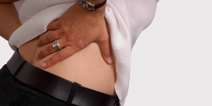 Dolor adolorido en la cintura desde la espalda de una mujer