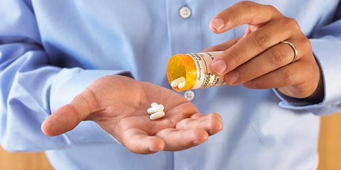 Un hombre toma antibióticos para la prostatitis.