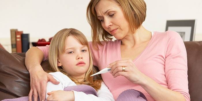 Mama mierzy temperaturę chorego dziecka