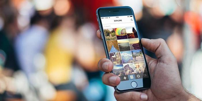 O cara está vendo fotos em um smartphone