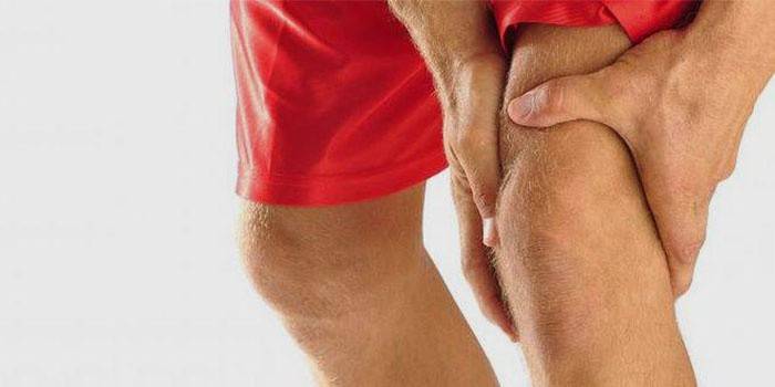 Un hombre tiene dolor de rodilla en el interior.