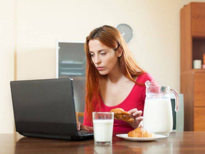 Menina come no computador