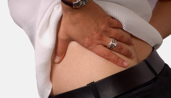 Una mujer tiene dolor de espalda que se extiende hasta el glúteo.