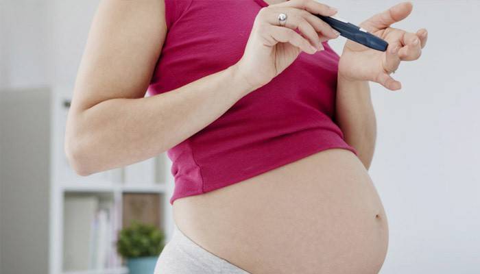 Una mujer embarazada controla su glucosa en sangre para detectar diabetes
