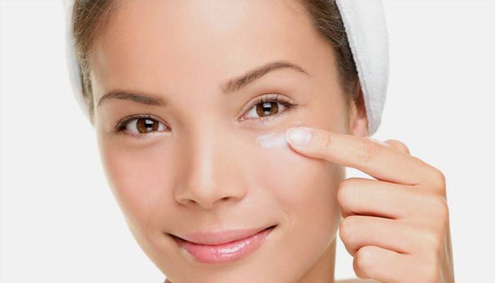 Garota coloca cosméticos sob os olhos