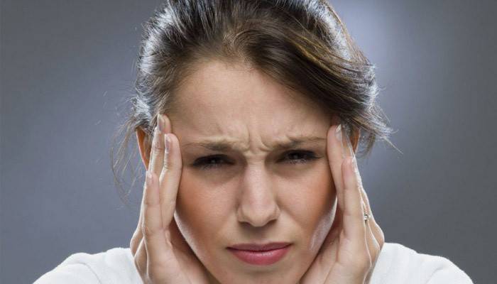 La mujer tiene dolor de cabeza.