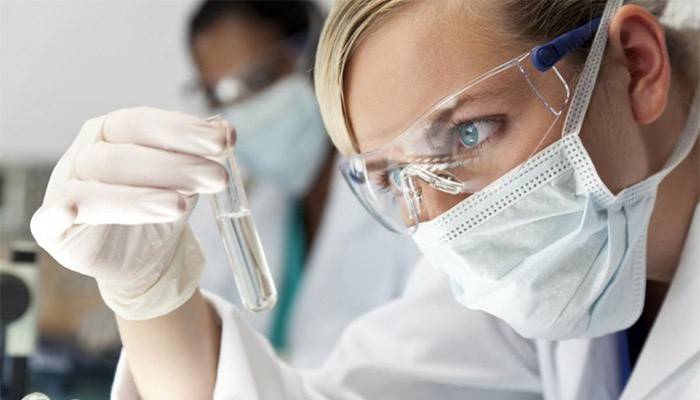 Technik laboratoryjny sprawdza zawartość probówki