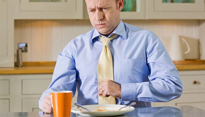 Peso no estômago depois de comer em um homem