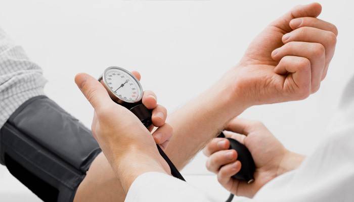 O médico mede a pressão do paciente
