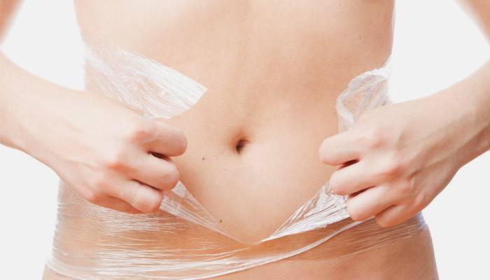 Chica hace una envoltura de grasa en la parte inferior del abdomen