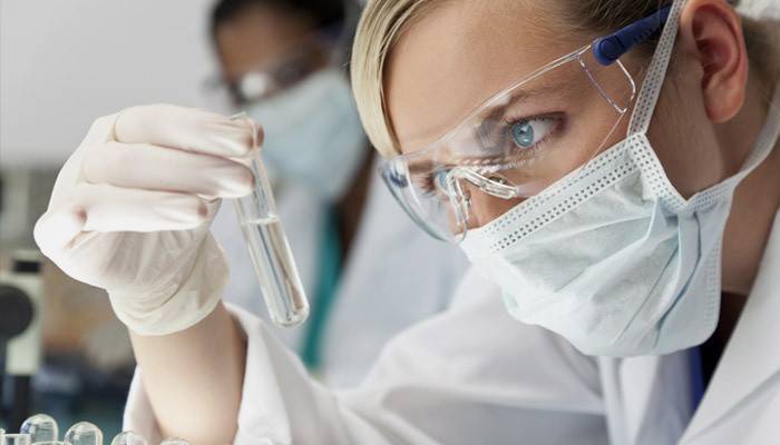 Asistente de laboratorio examina resultados de análisis
