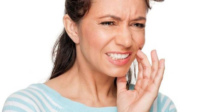 Uma mulher tem uma dor de dente