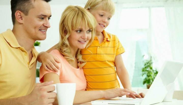 Familia con un niño mirando la pantalla de una computadora