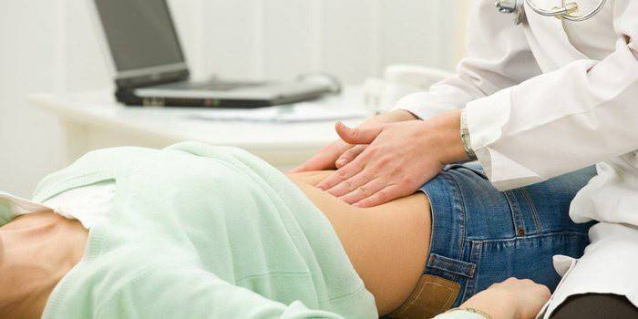 Palpación del estómago en el diagnóstico de gastritis erosiva.