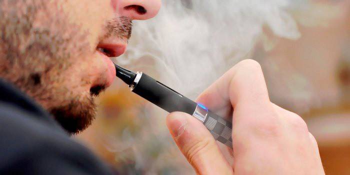 Un hombre fuma un cigarrillo electrónico.