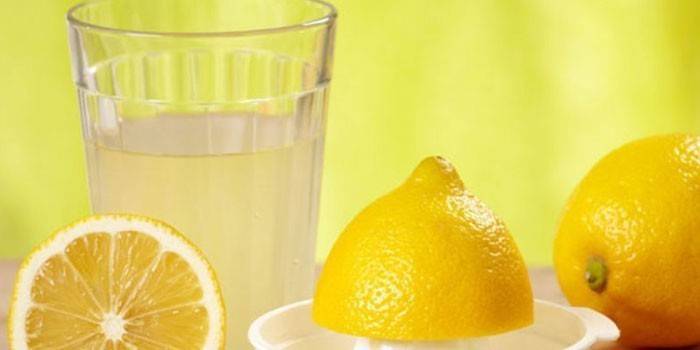 Suco de limão em um copo e limões