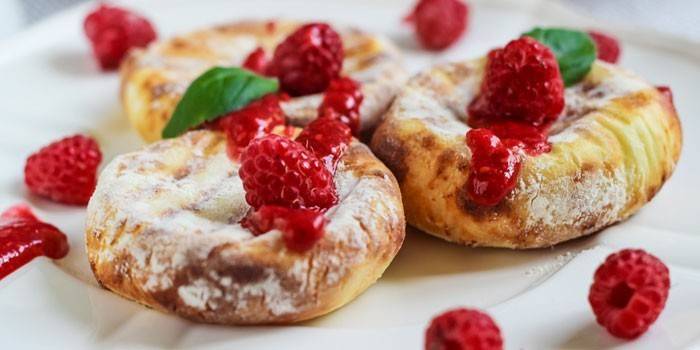 Tartas de queso con azúcar en polvo y frambuesas