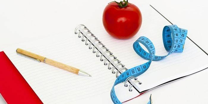 Diario de alimentos, bolígrafo y centímetro.