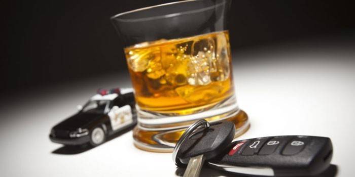 Coche de policía, llave del coche y whisky en un vaso