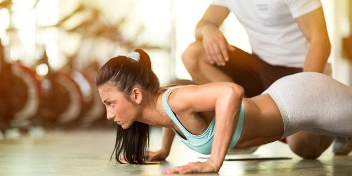 La niña participa en el gimnasio con un entrenador