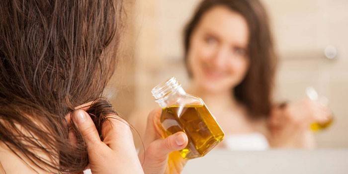 Chica pone aceite de amaranto en su cabello