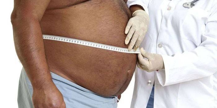 Los hombres miden el estómago con un centímetro