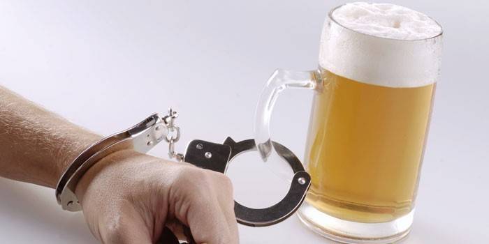 Vaso de cerveza esposado a una mano