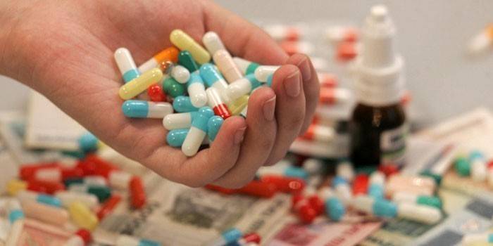Medicamentos na mesa e na palma da mão