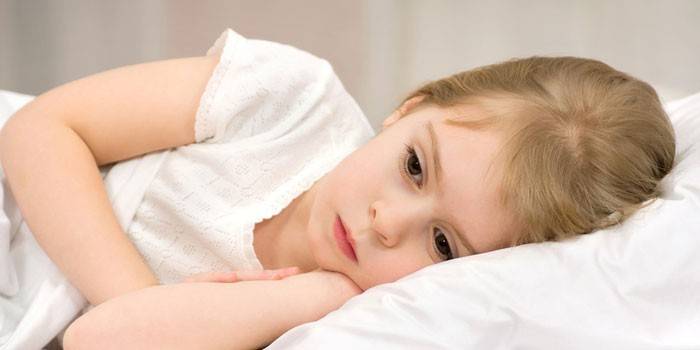 La niña yace en la cama
