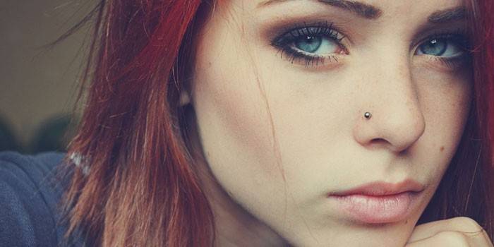 Chica tiene piercings en la nariz