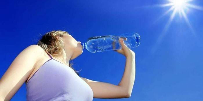 Niña bebe agua de una botella