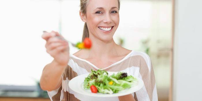 Niña sostiene un plato con ensalada